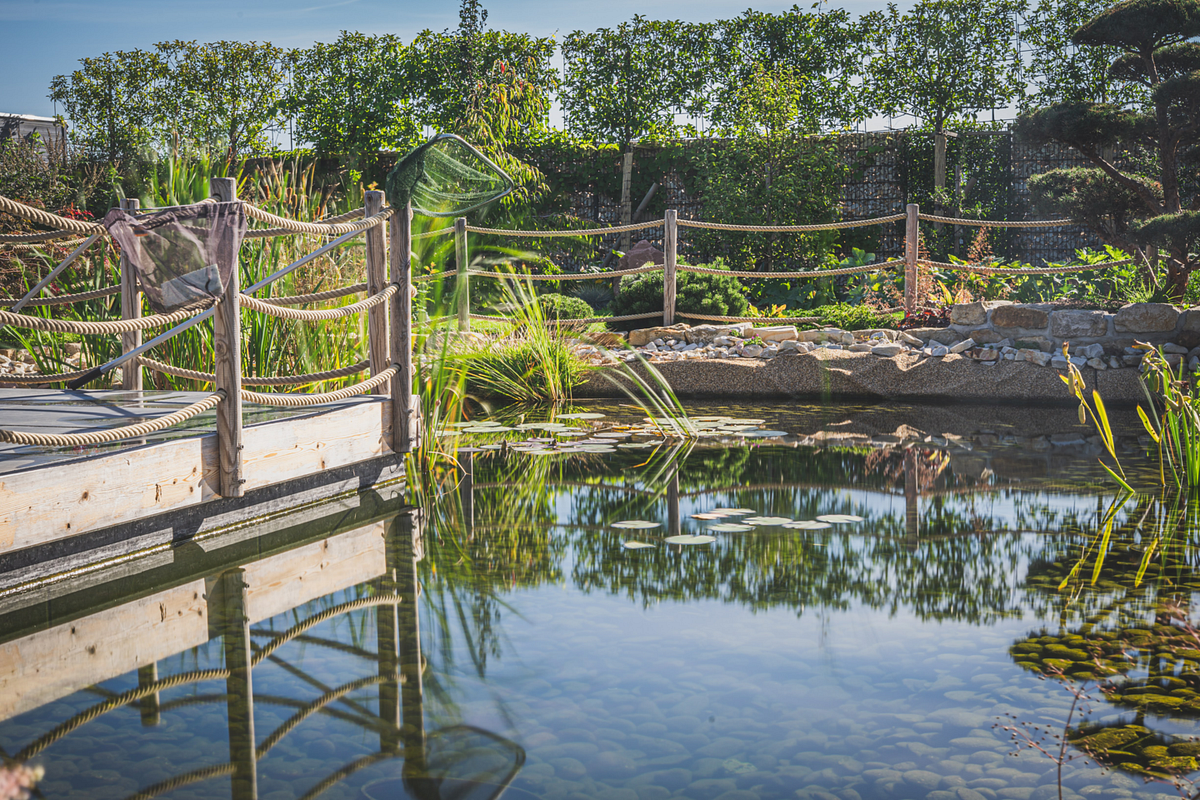 Idyllischer Gartenteich mit einem Holzsteg